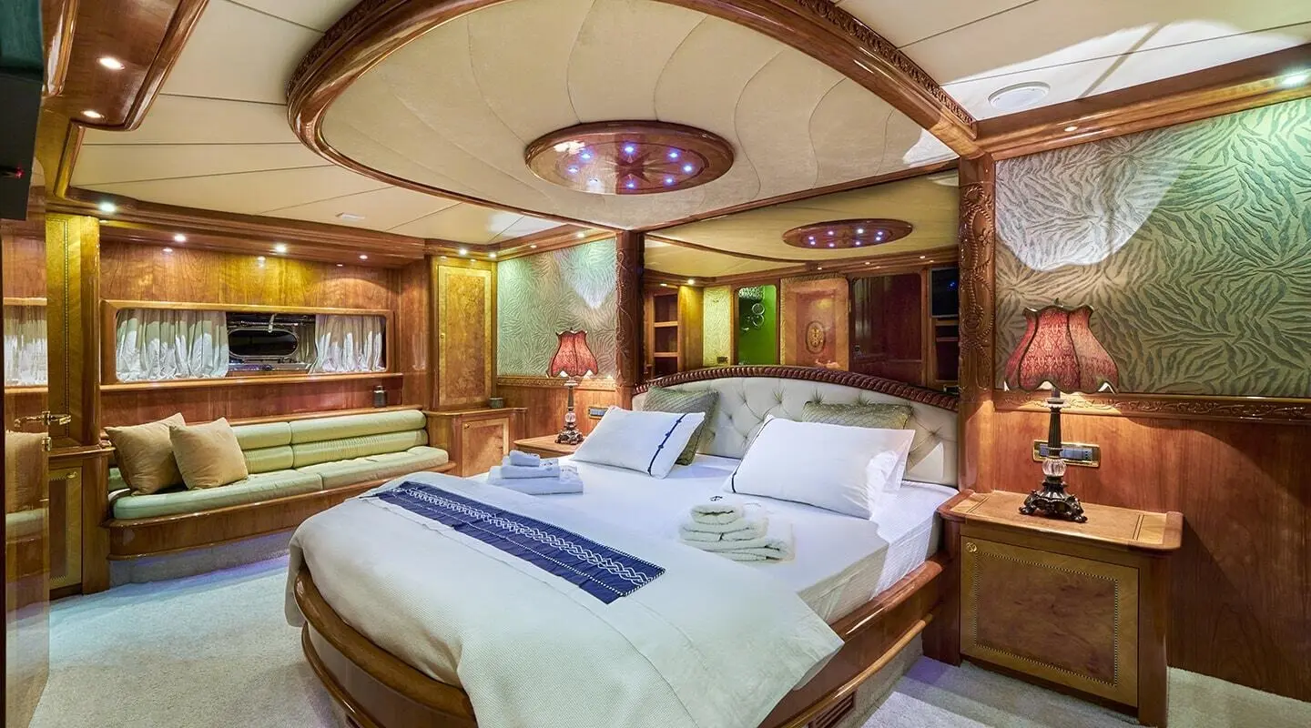 Luxurious master cabin on a gulet yacht Lotus with wood paneling and framed bed