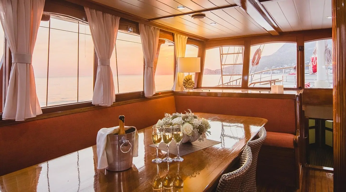 Interior of a luxury yacht Altair with wooden beams, table set for dining