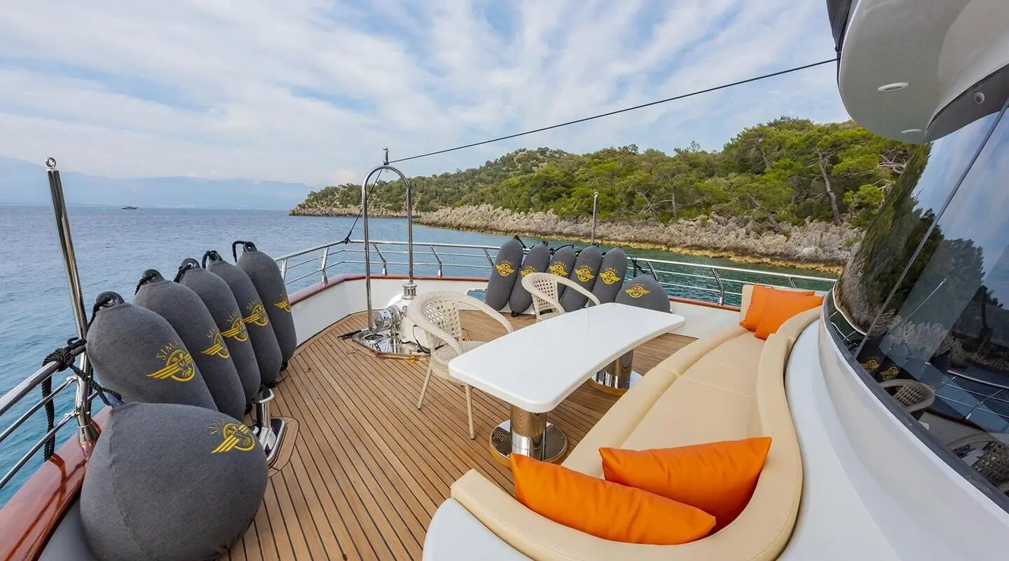 Yacht Simay M deck view with sun loungers, seating area, and coastline