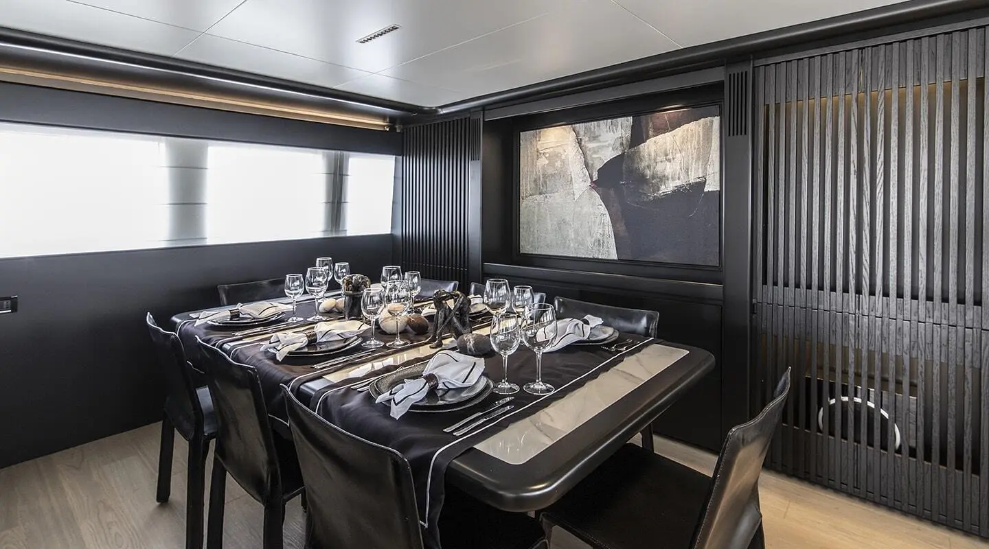 Luxurious yacht Project Steel dining salon with table settings and dark wood seating