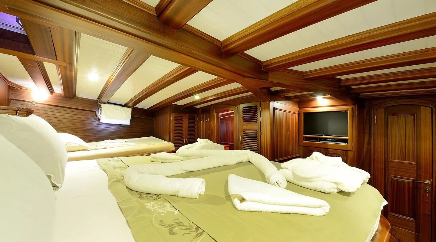 Zephyria II master cabin aboard gulet with wooden beams and neatly folded towels
