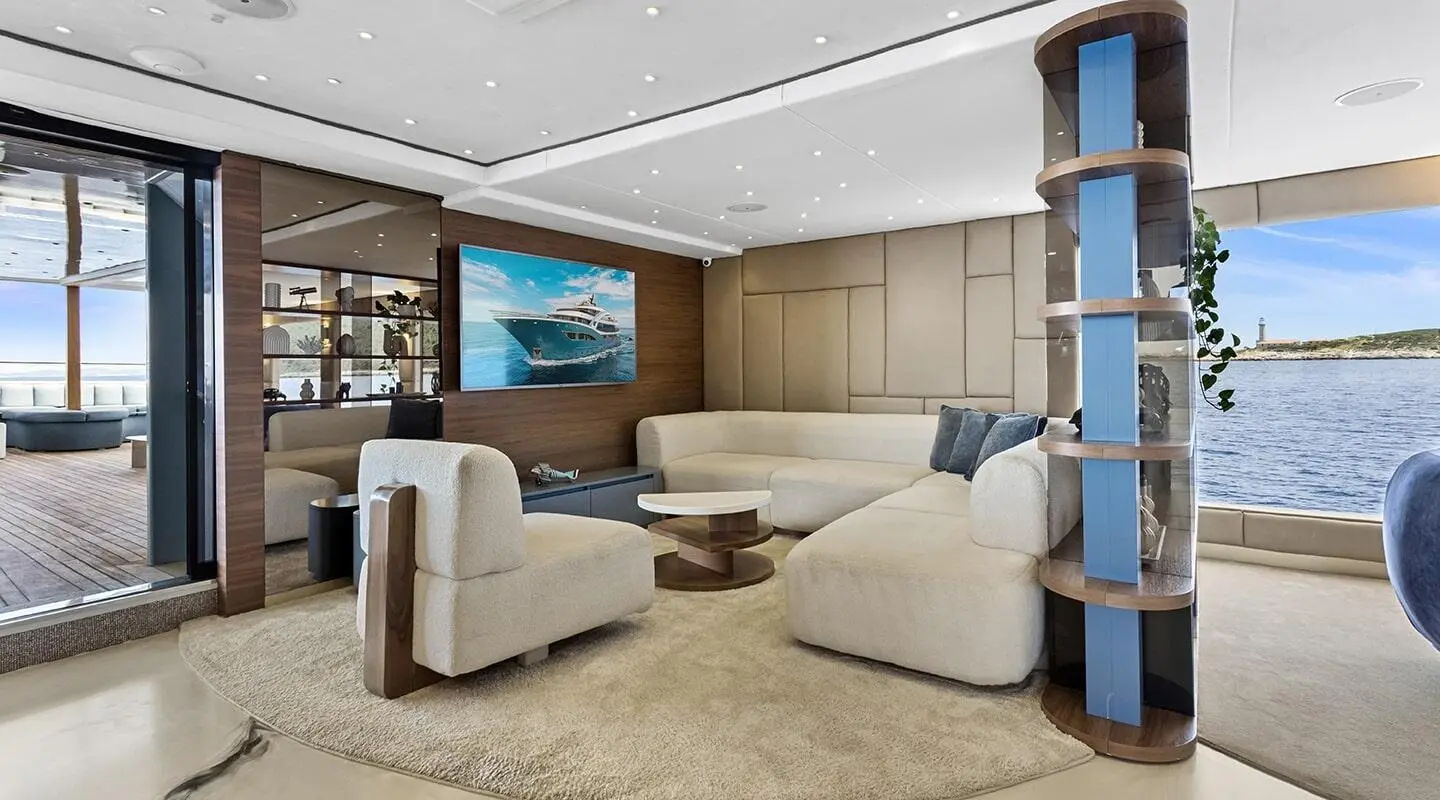 Bella motoryacht salon with beige seating, wooden cabinetry, and a wall-mounted TV