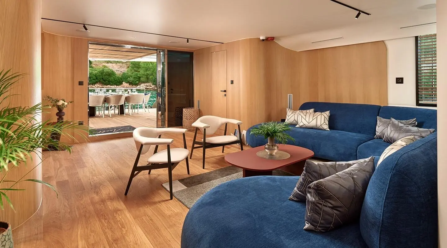 Interior of Anetta luxury motor yacht saloon with blue seating and wooden furnishings