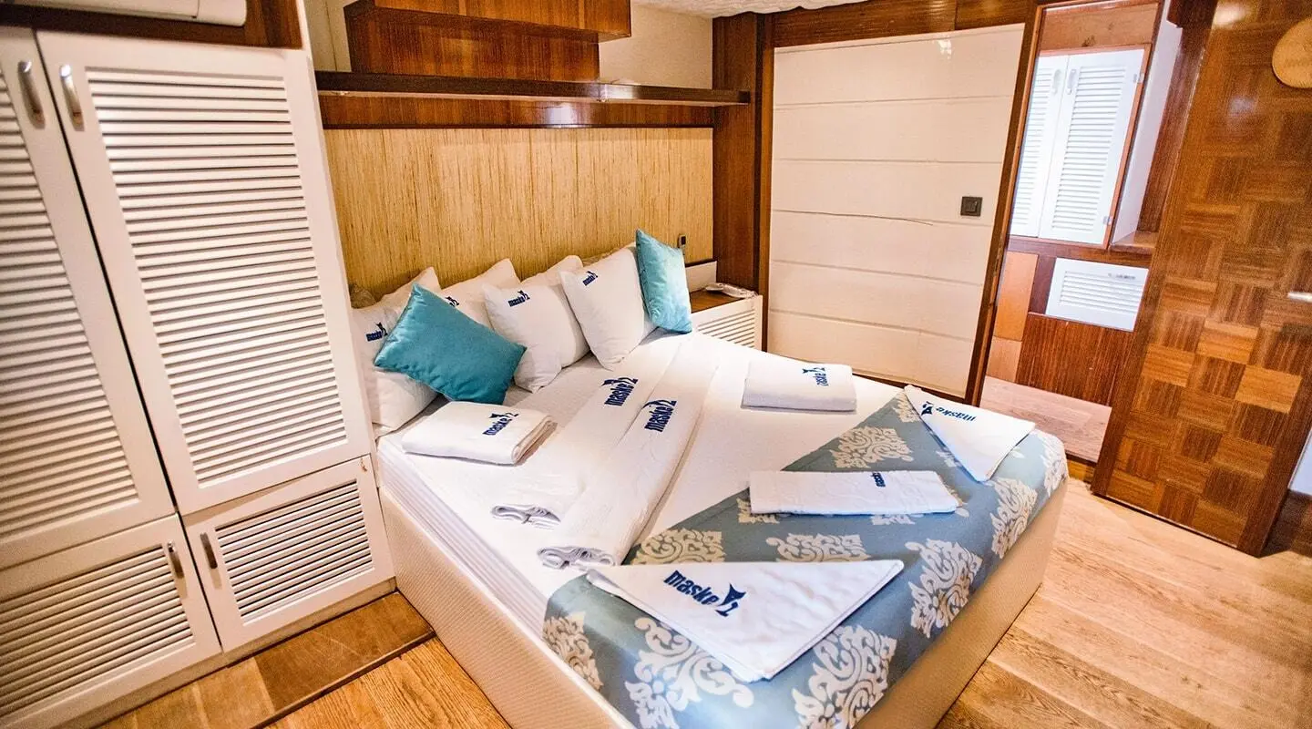 Maske 2 yacht seen from cabin with upholstered bed and blue cushions