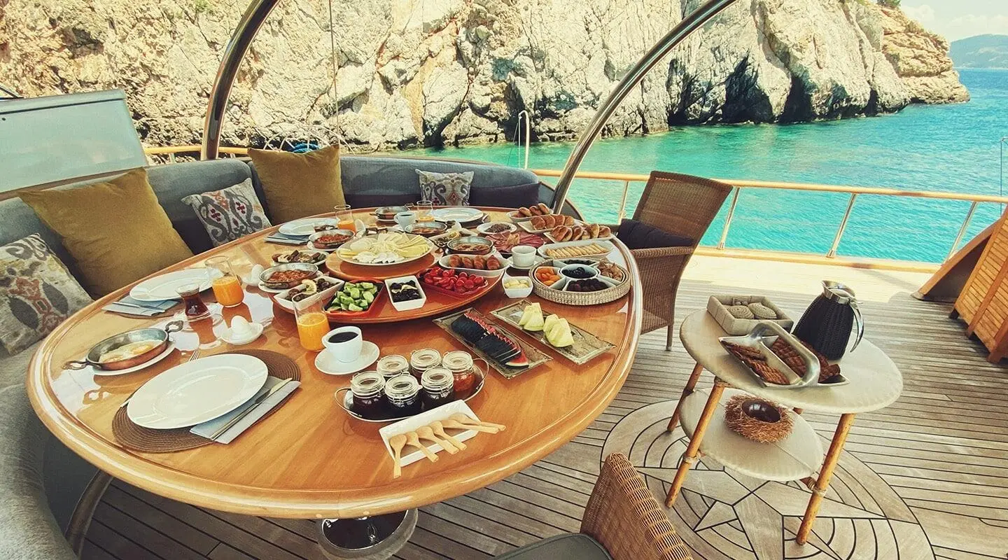 Table set with drinks and snacks on a wooden deck aboard Silver Moon yacht