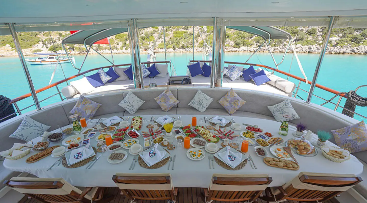 Aft deck dining setup on Prenses Esila gulet with plates and glassware
