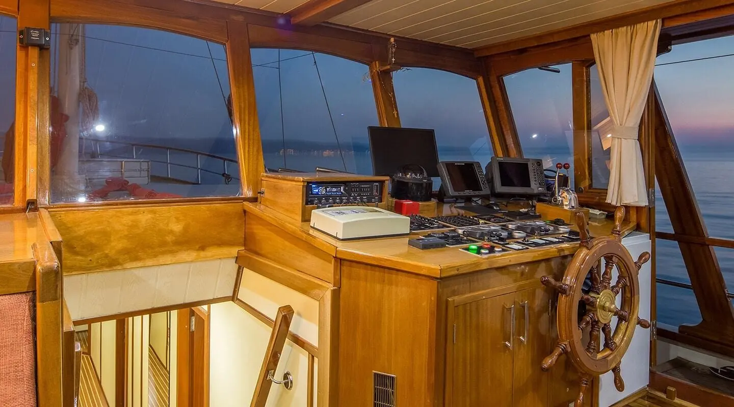 At sunset on a luxury gulet, polished wooden deck and helm area aboard Altair