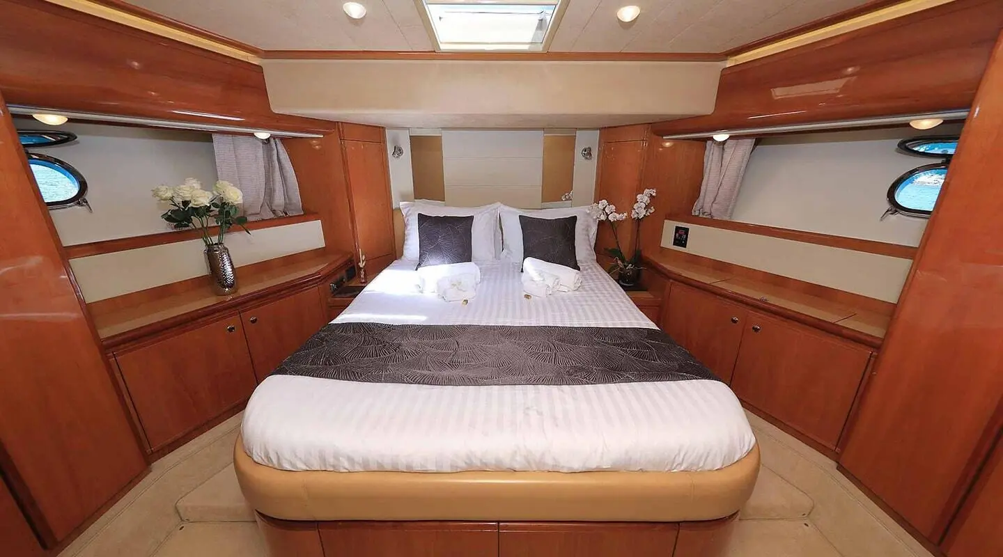 Interior view of Quo Vadis I yacht: forward cabin with two beds and wood paneling