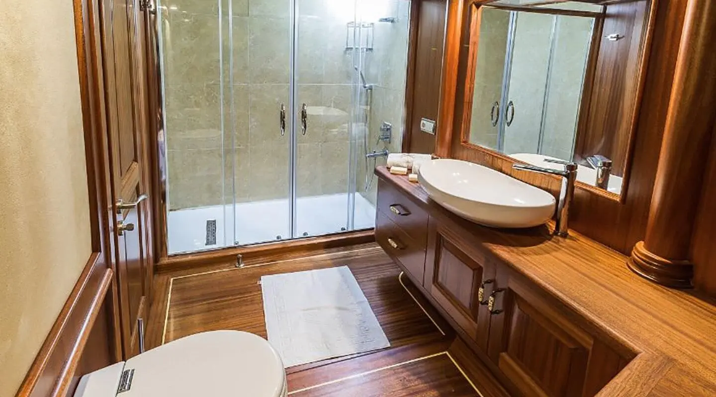 Halcon Del Mar luxury gulet bathroom with glass shower, wooden accents and sink