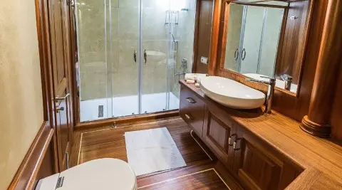 Halcon Del Mar luxury gulet bathroom with glass shower, wooden accents and sink