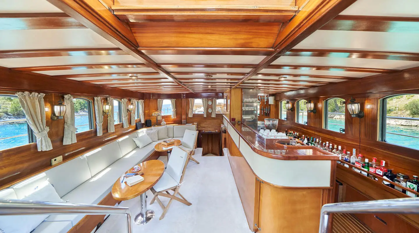 Luxurious yacht Libra interior with polished wood, seating, and sails visible