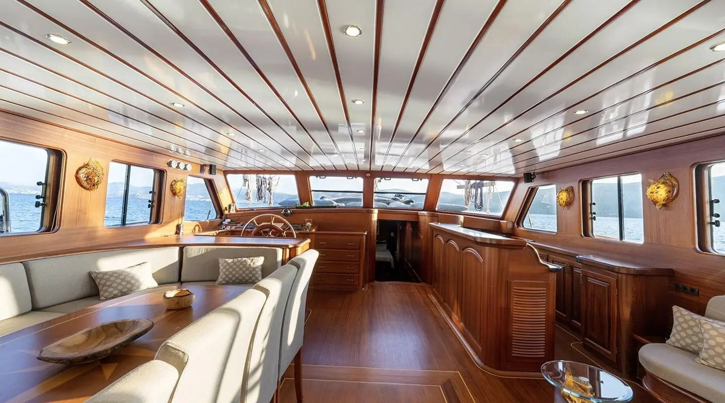 Inside deck of luxury gulet with wood paneling, seating and windows
