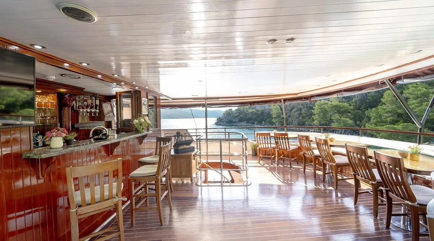 Cesarica luxury yacht interior deck with wooden chairs and sunset view