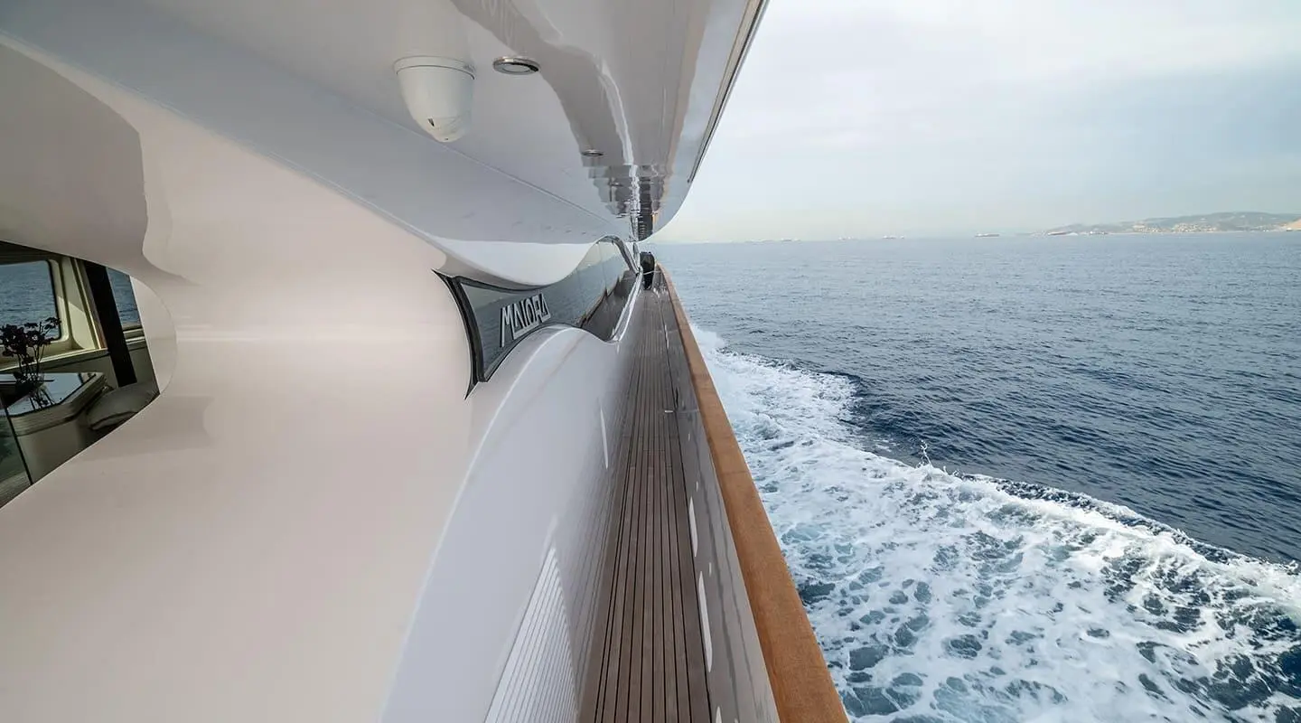 Side deck view of Pareaki II yacht with polished railing and sea spray