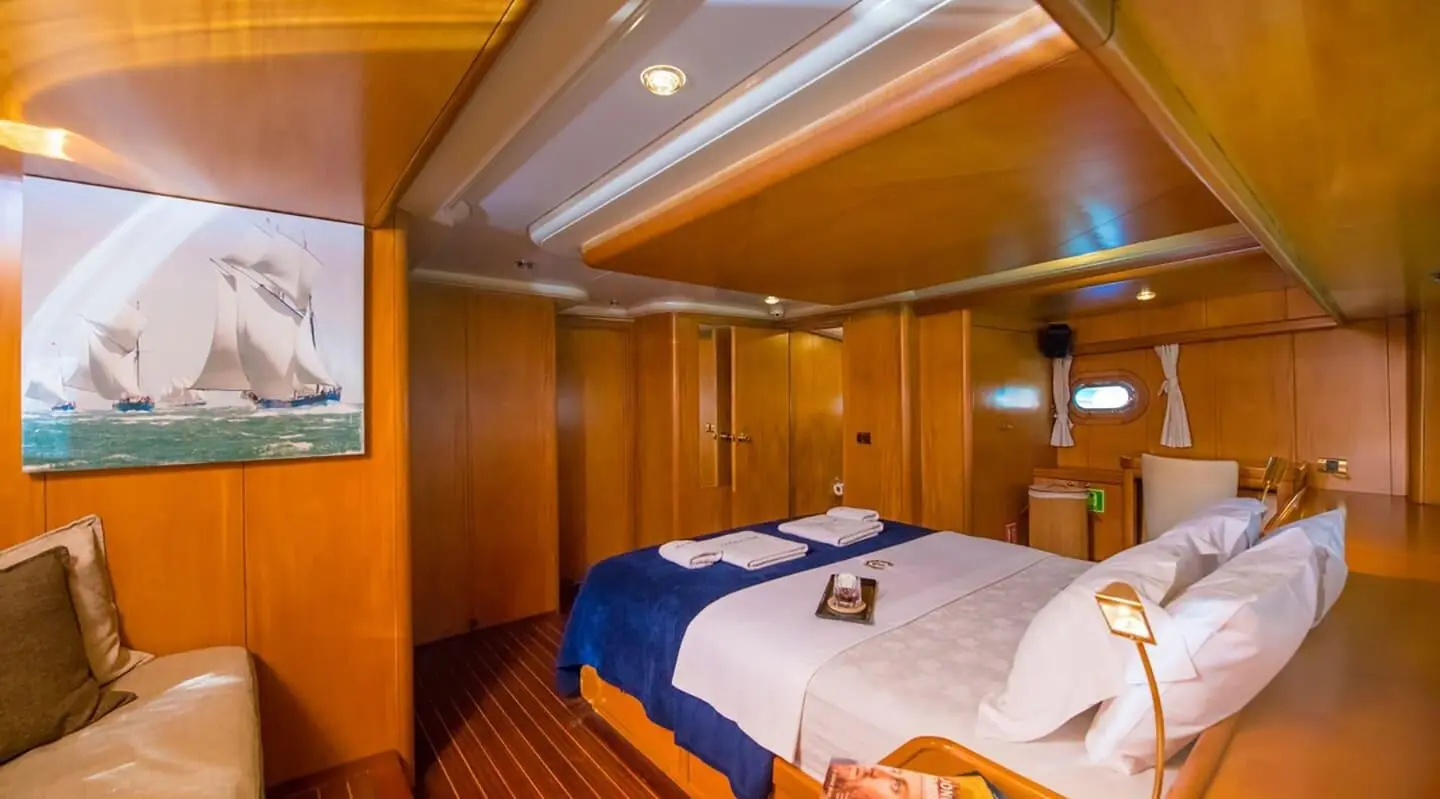 Interior of Mein Schatz gulet cabin with neatly made double bed and wood paneling