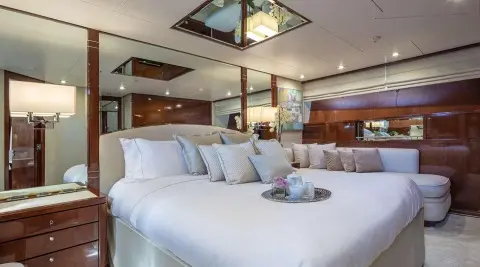Grace yacht’s luxurious master cabin with plush white bedding and mirrors
