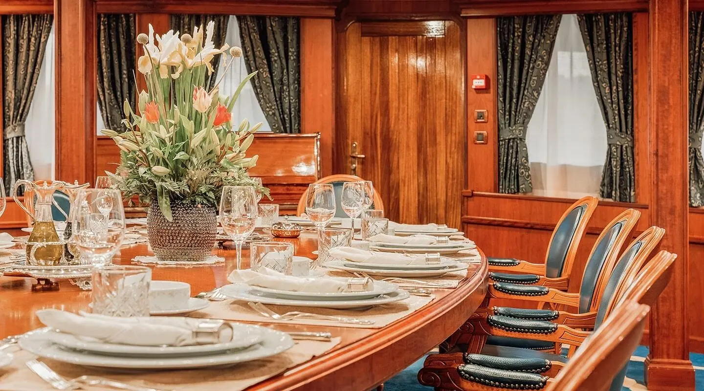 Seagull II dining area aboard luxury yacht with polished wood table and place settings