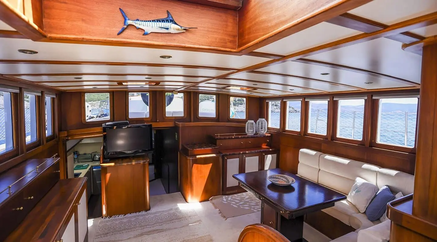 Interior of a wooden yacht cabin with a TV and seating area