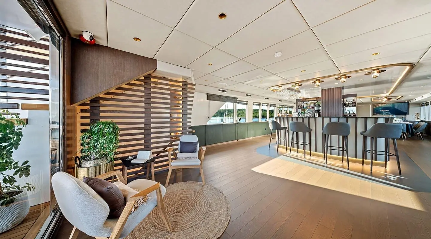 Indoor lounge area with bar, wooden decor, and seating around a rug