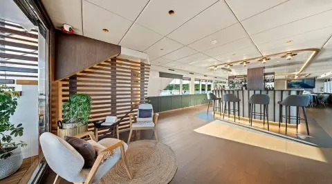 Indoor lounge area with bar, wooden decor, and seating around a rug