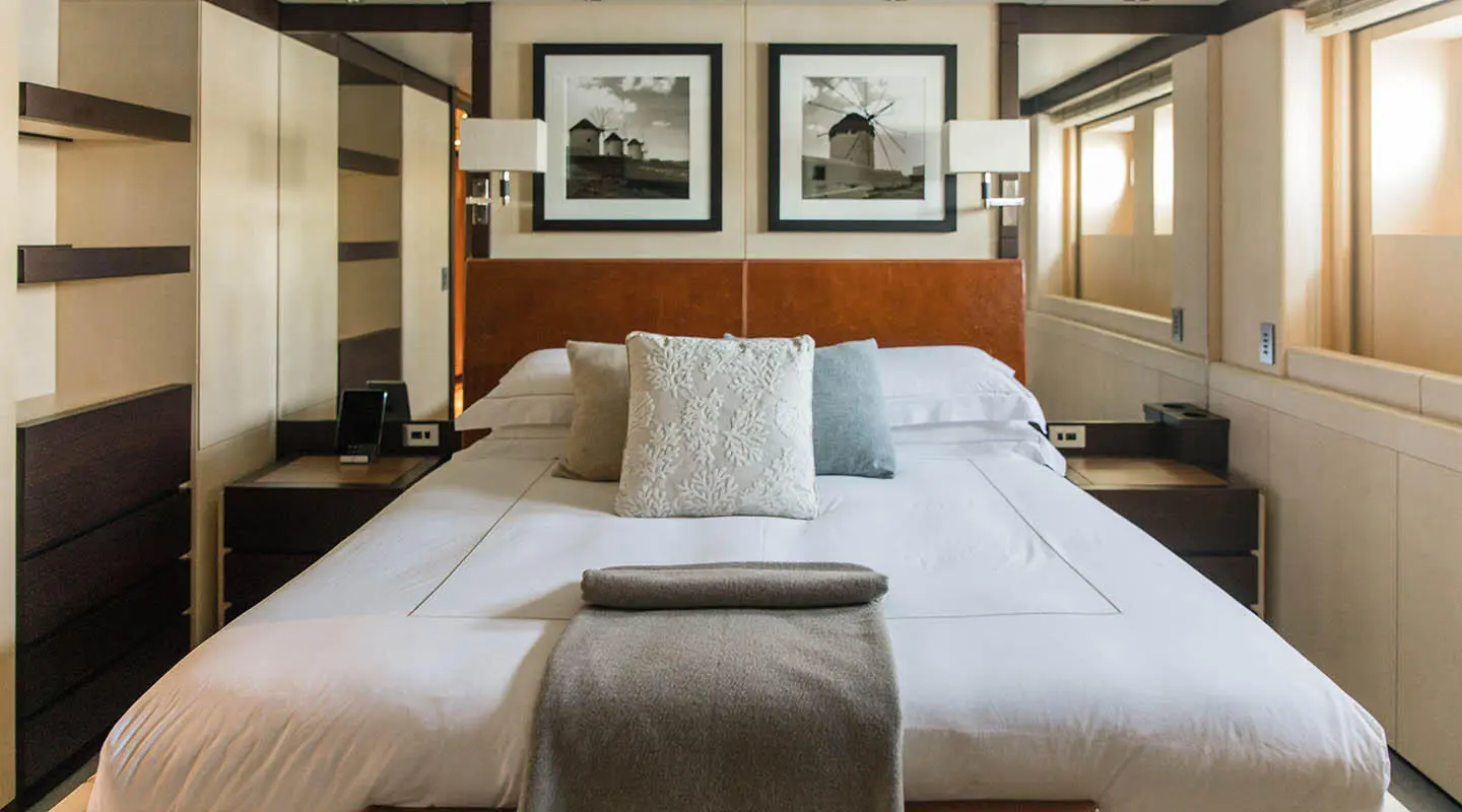 Cozy luxury yacht Alalya bedroom with large bed, pillows, and warm lighting