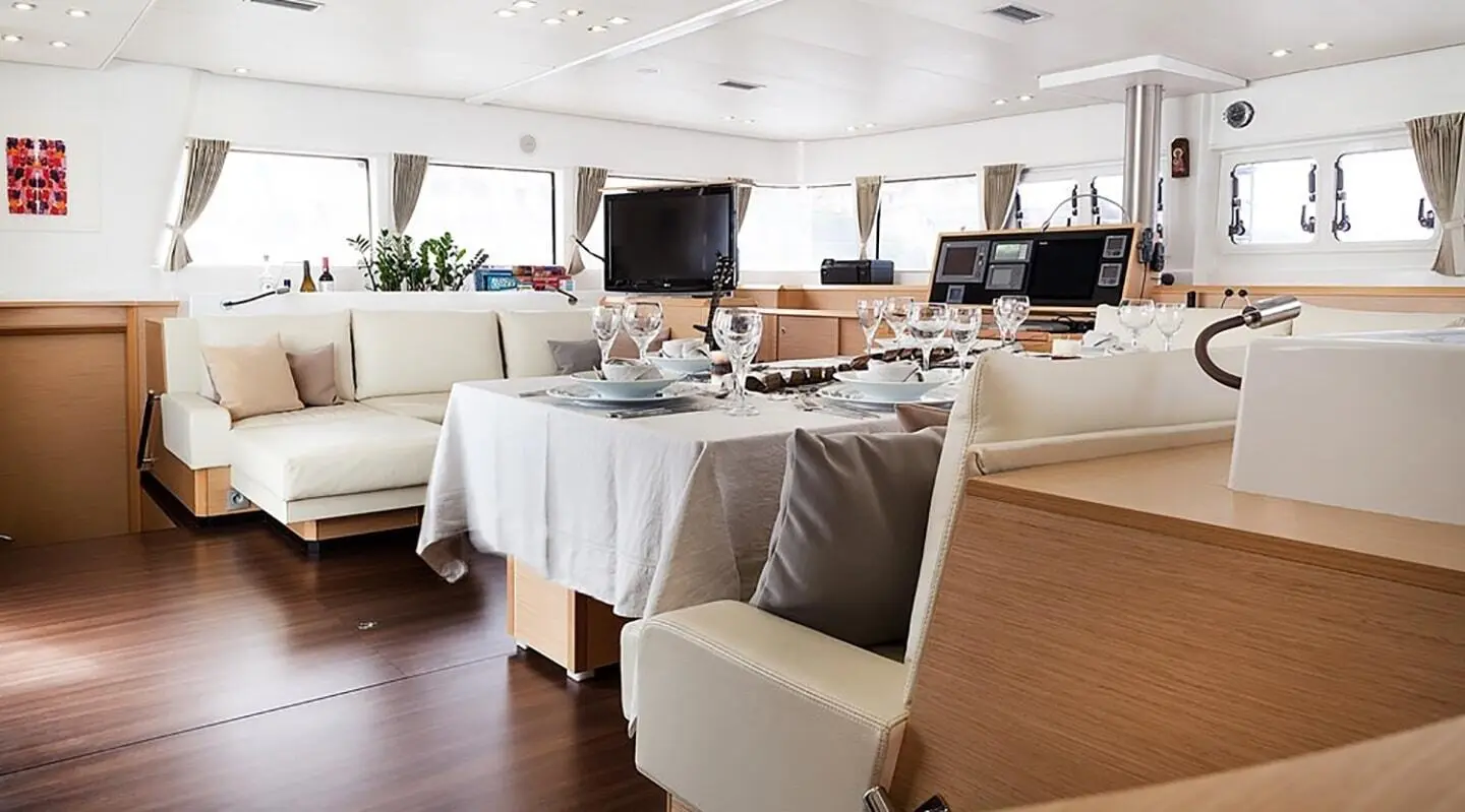 Light-colored yacht saloon with dining table and seating area