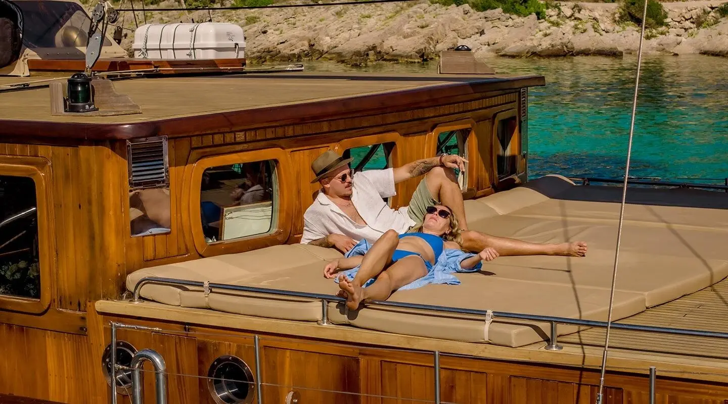 Smart Spirit yacht with two children on sun deck at sunset, wooden cabin visible