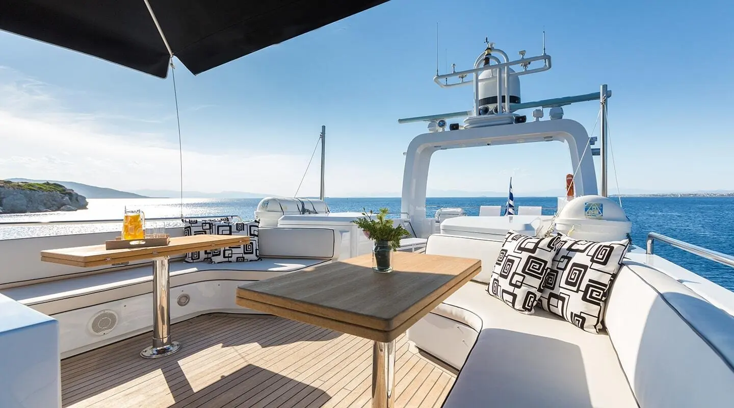 Aquarella yacht sun deck with seating, table, and ocean view at sunset