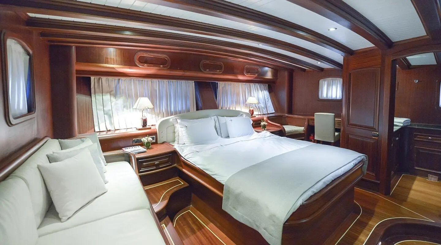 Master bedroom with white bedding, wood interior and luxurious yacht cabin
