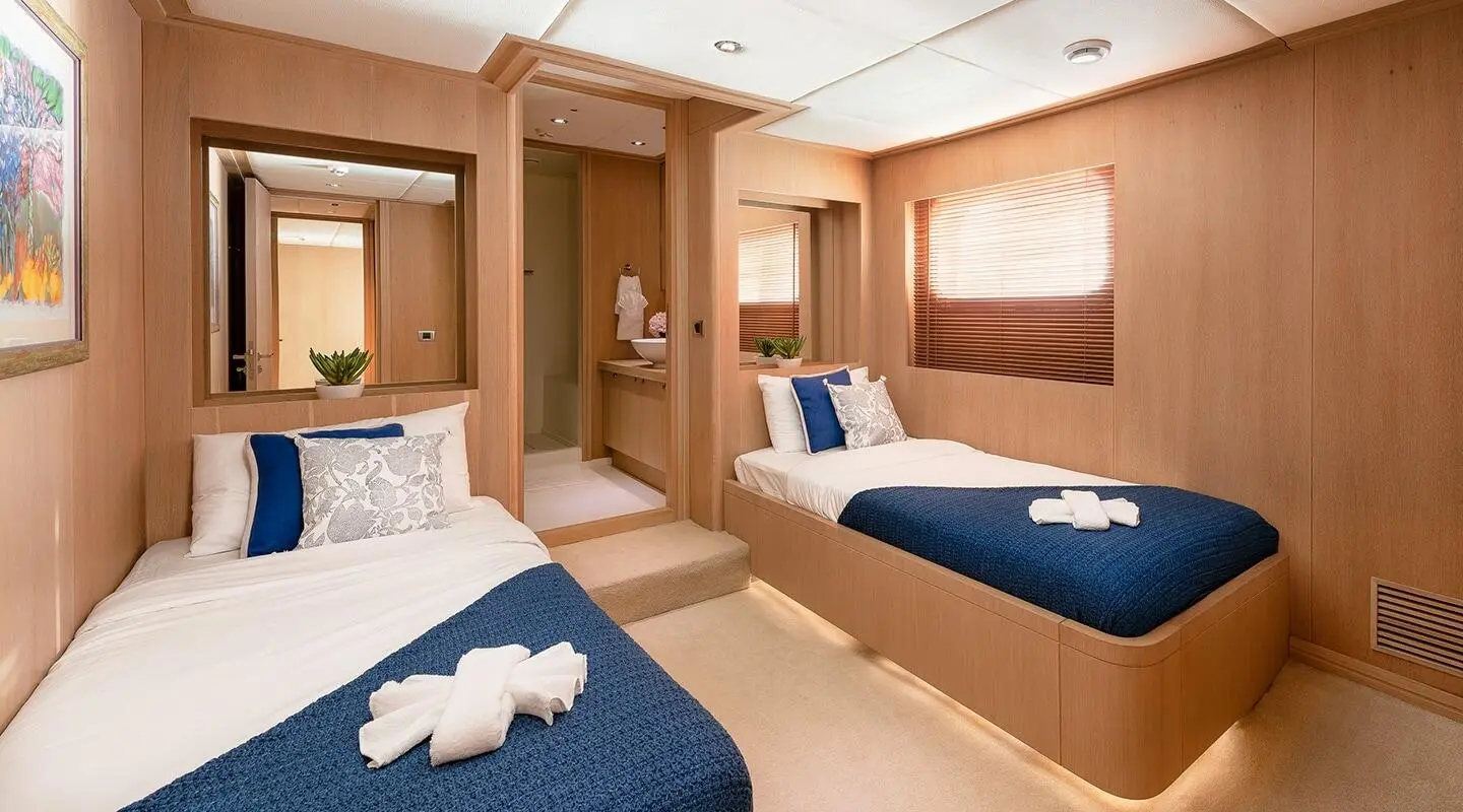 Interior of Grace yacht: twin beds, wood paneling, seating, and a small lounge