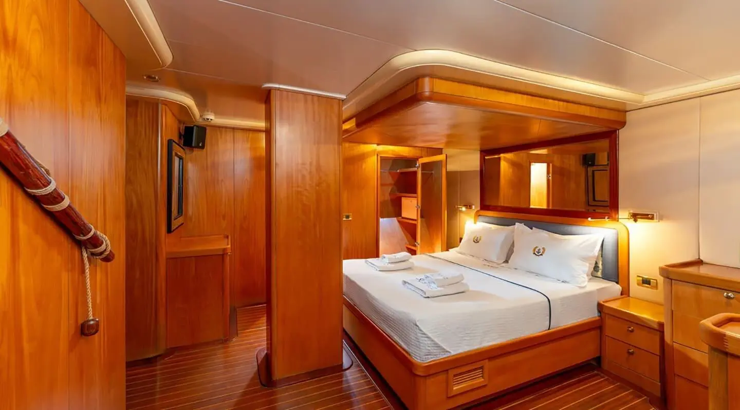 Interior of a wooden cabin with a double bed on a gulet yacht