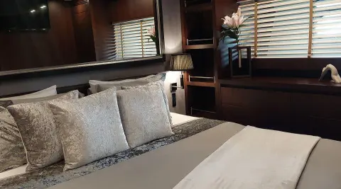 Luxurious yacht Miraval bedroom with bed and wood paneling interior