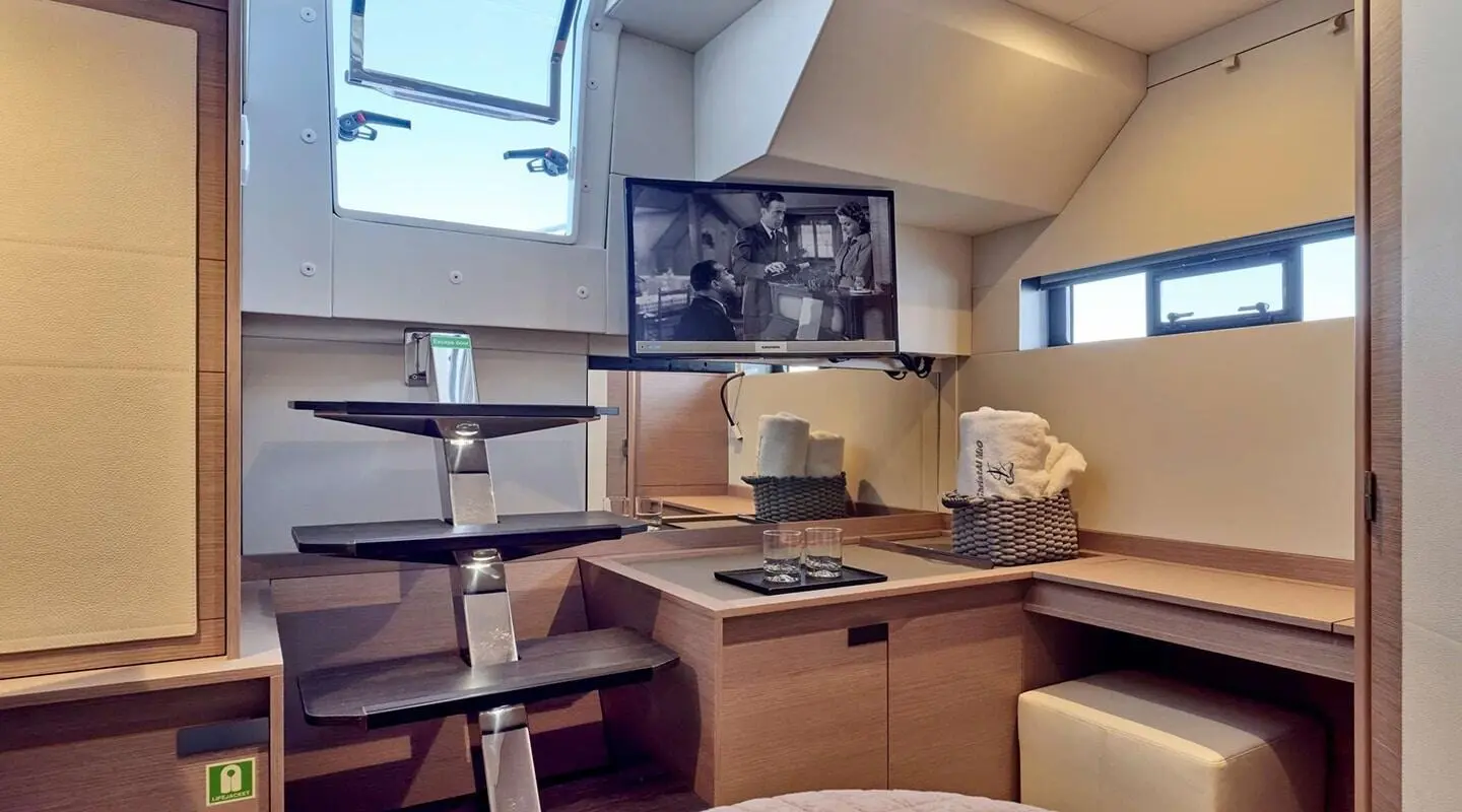 Inside yacht Christal Mio: navigation station with wooden panels and seating