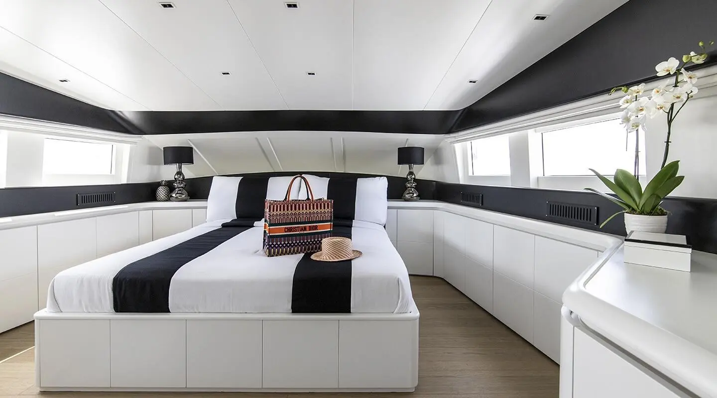 Luxurious yacht bedroom with white cabinetry, large bed, and dark accents