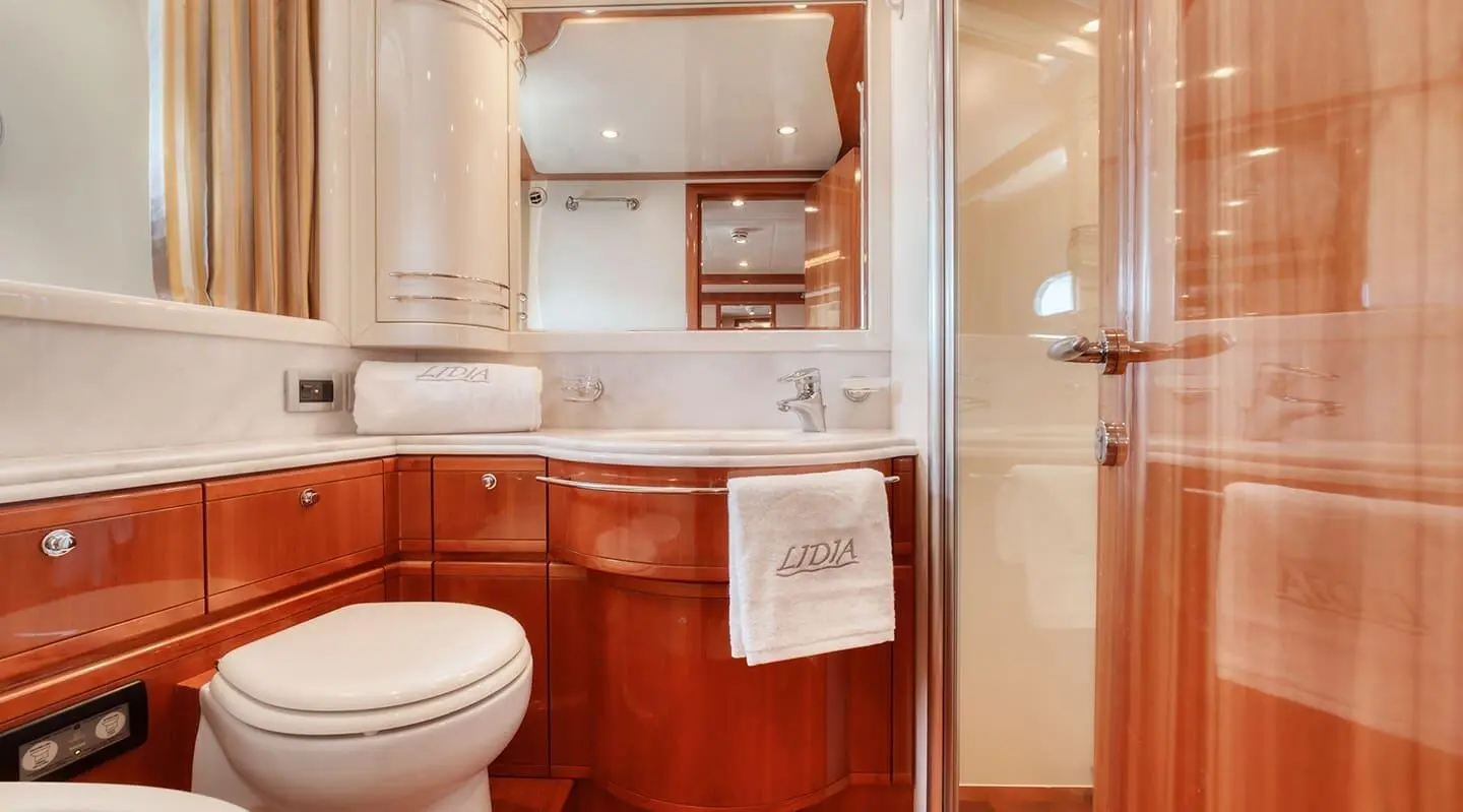 Bathroom of the Lidia yacht with wood veneer cabinets and mirrored cupboards