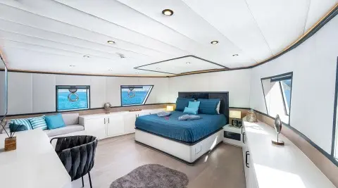 Calm Down yacht interior: bright living area with blue sofa seating and large windows
