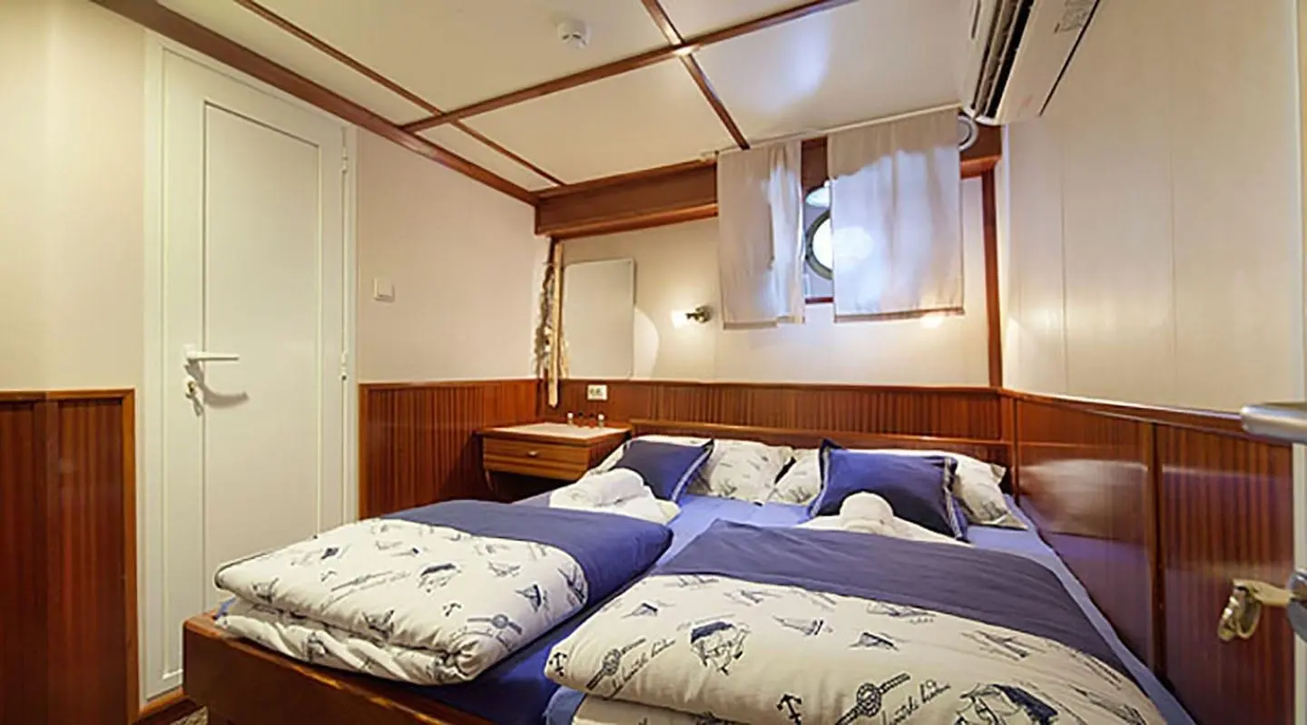 Luxurious sailing yacht Tajna Mora interior with twin beds and porthole window