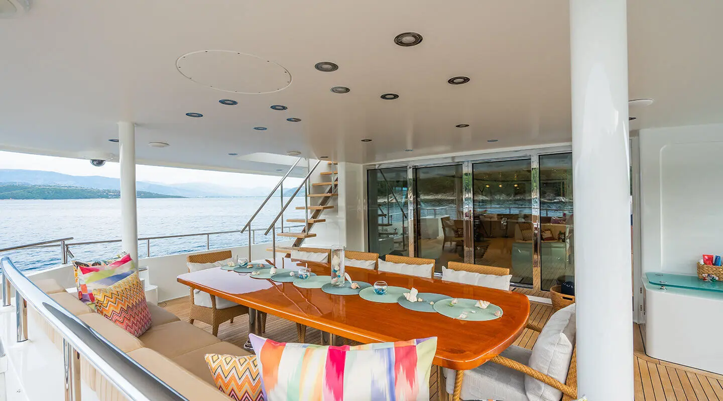 Dining table aboard Serenity yacht with plates, glassware, and nautical view