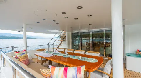 Dining table aboard Serenity yacht with plates, glassware, and nautical view