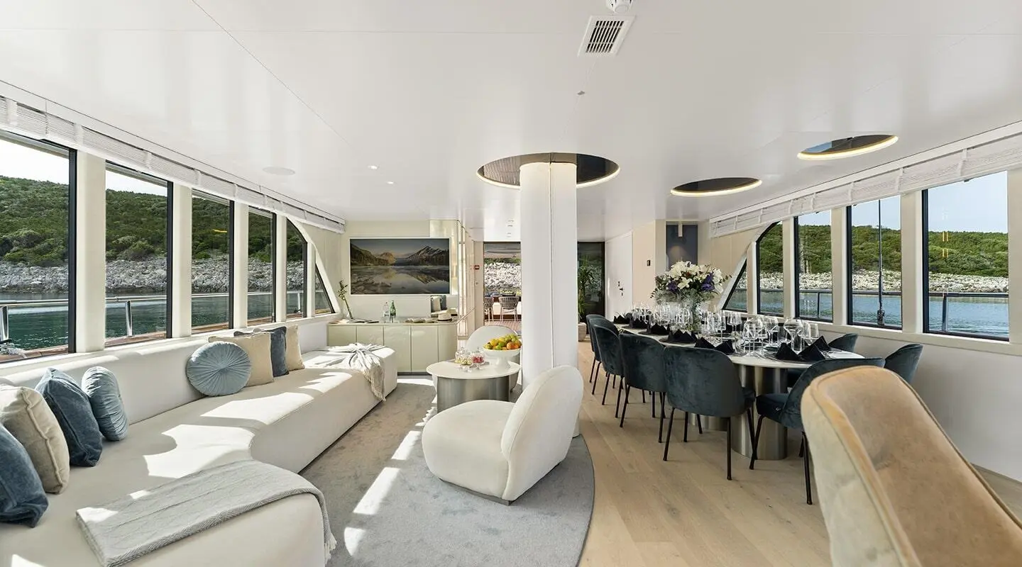 Luxurious yacht salon aboard Maxita with white leather seating and large windows
