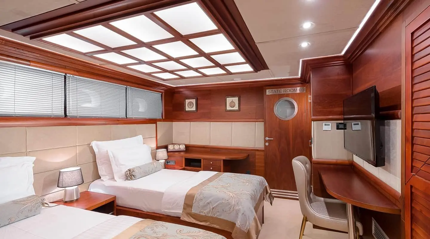 Bedroom aboard Lady Gita yacht with two single beds and wood paneling