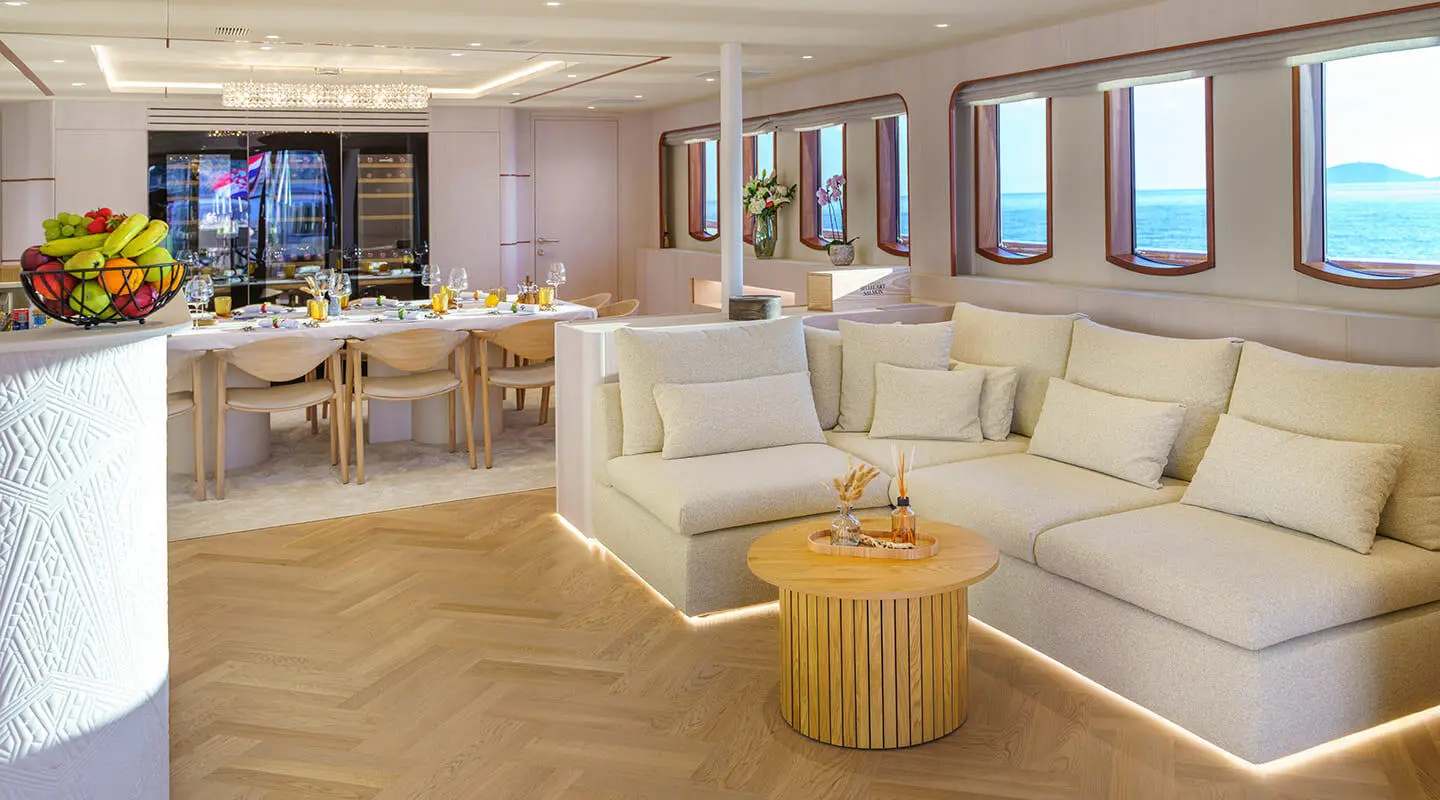 Maia luxury yacht salon interior with cream sofas, wooden coffee tables, and windows