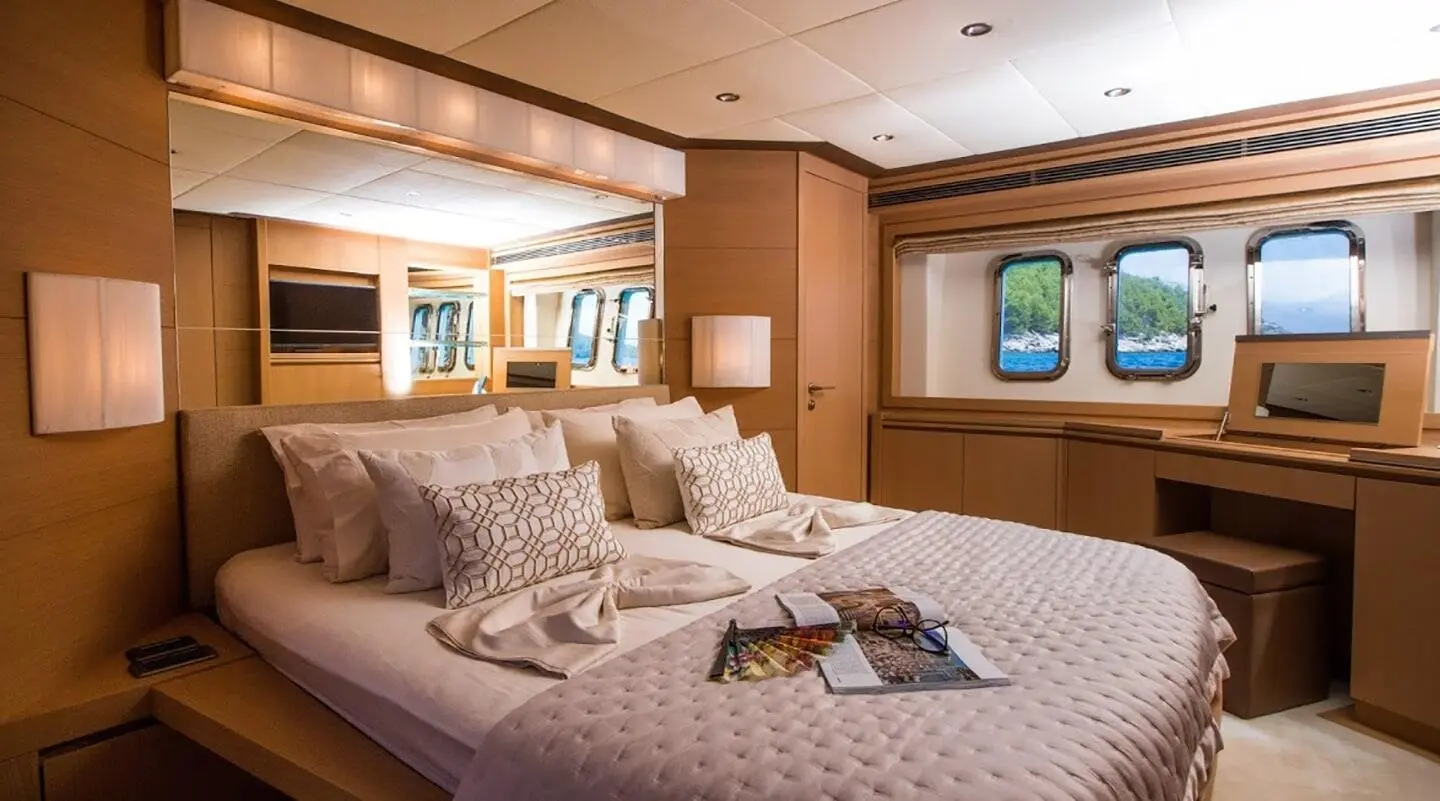 Interior bedroom with plush bed, decorative pillows and wooden cabinets