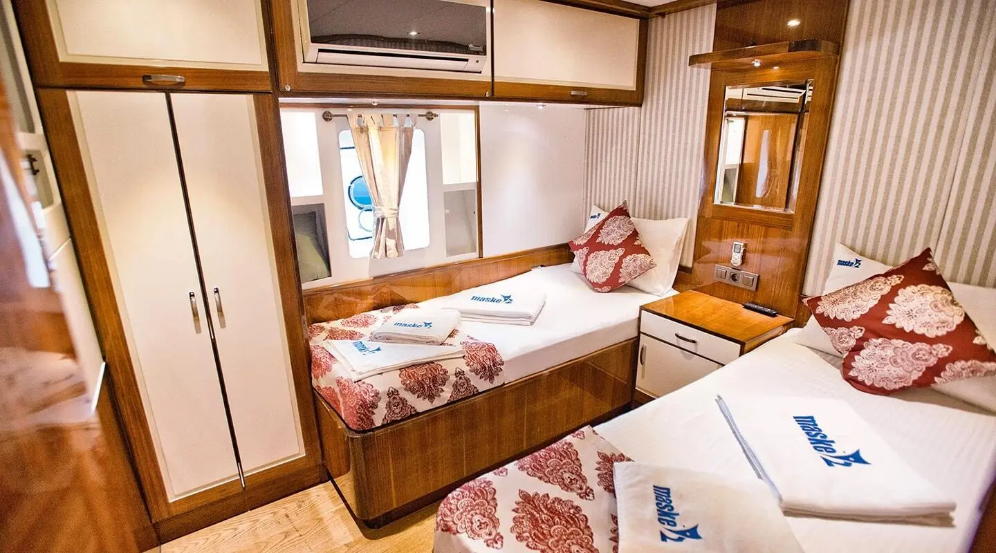 Maske 2 yacht interior with twin berths and wooden cabinetry