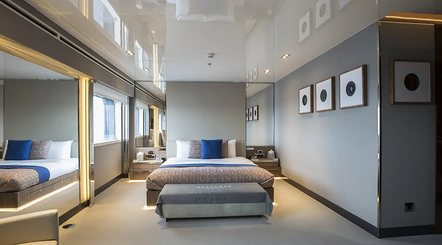 Marquise luxury yacht cabin with king bed, blue accents, wall art, and ambient lighting