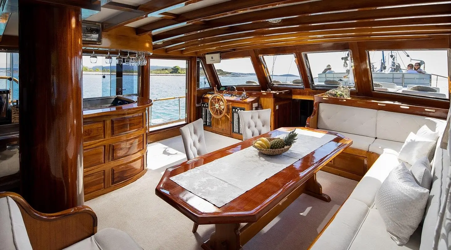 Gulet Andi Star saloon with cushioned seating, wooden table, and open deck view