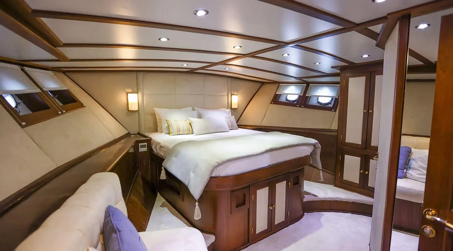 Gazella luxury yacht interior stateroom with plush bed and wood cabinetry