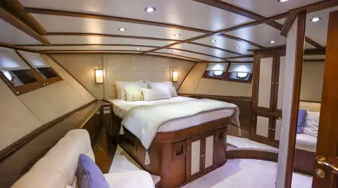 Gazella luxury yacht interior stateroom with plush bed and wood cabinetry
