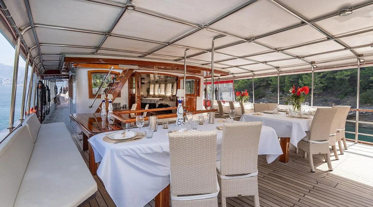 Barbara yacht aft deck seating area under a covered canopy with light chairs
