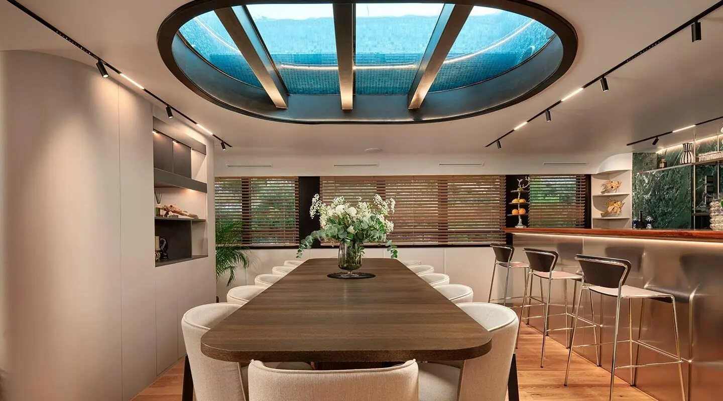 Anetta yacht dining area with a long table, beige seating, and a sunlit skylight